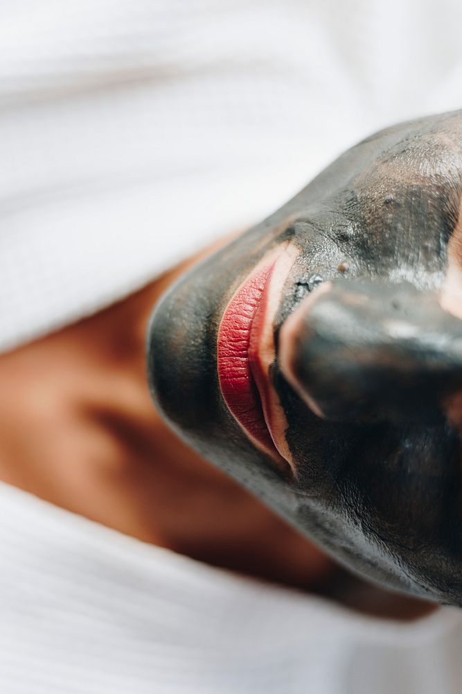 Woman relaxing with a charcoal facial mask