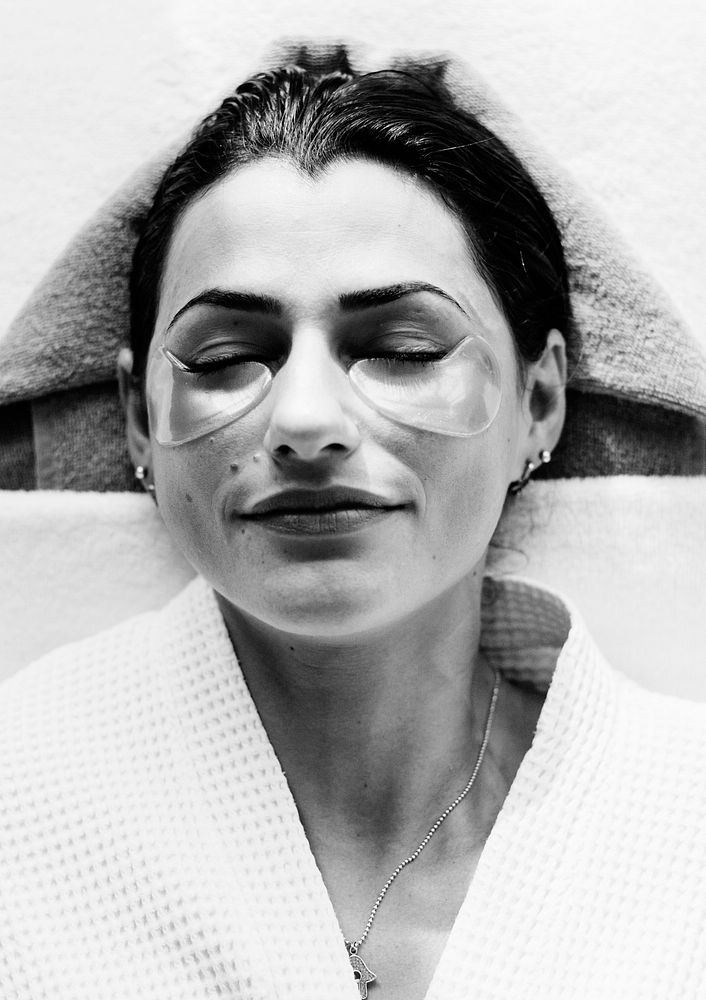 Woman relaxing with a golden eye mask treatment