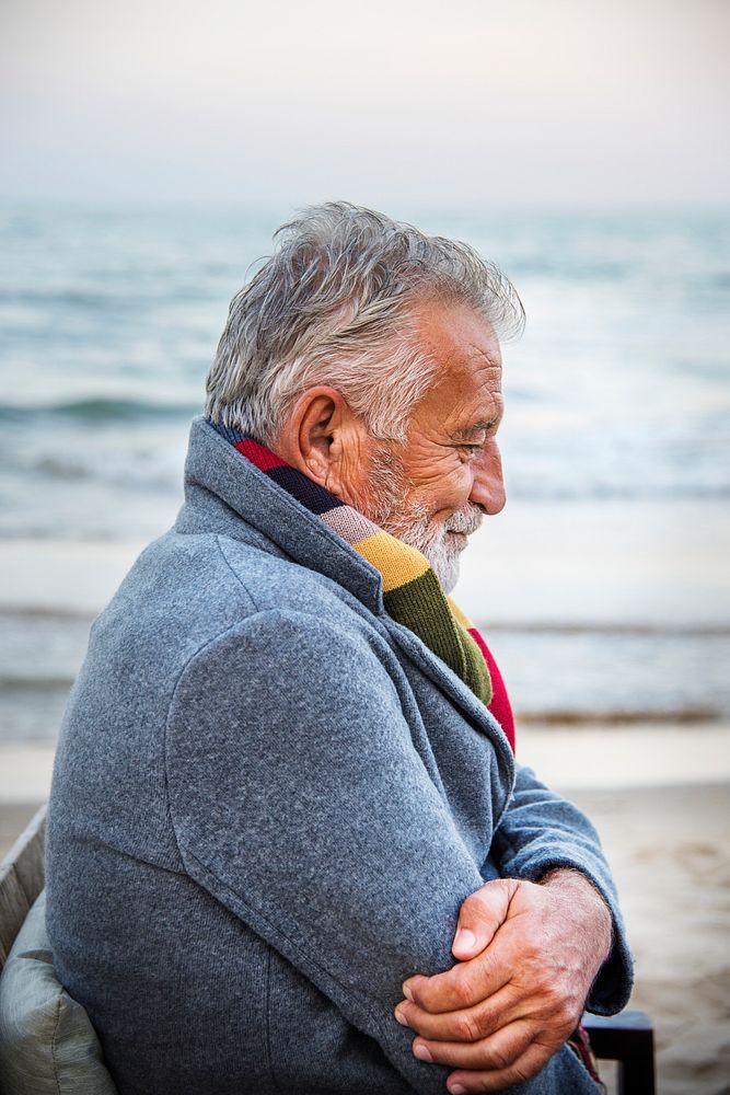 Mature man sitting on a chair by the seashore