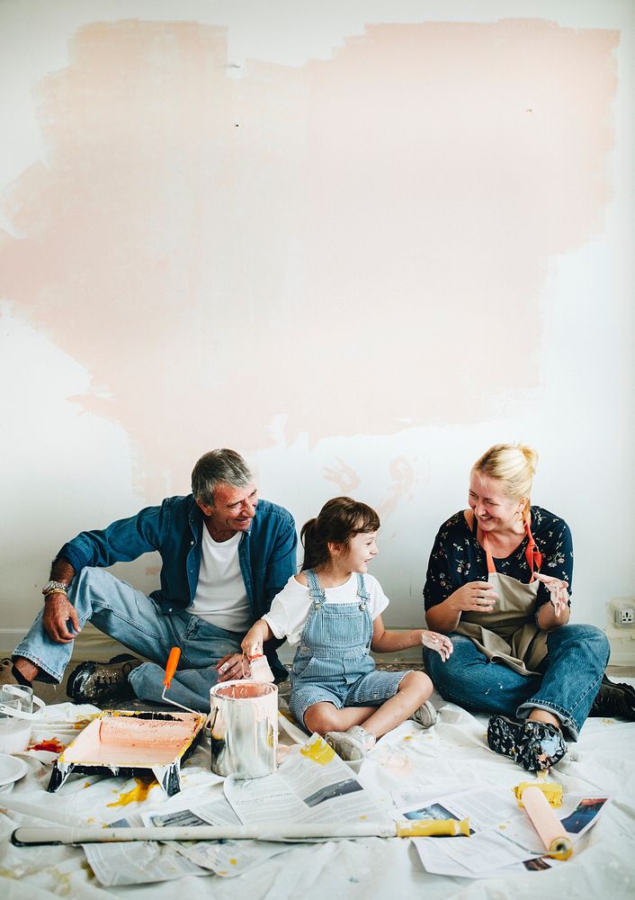 Cheerful family relaxing after painting the walls