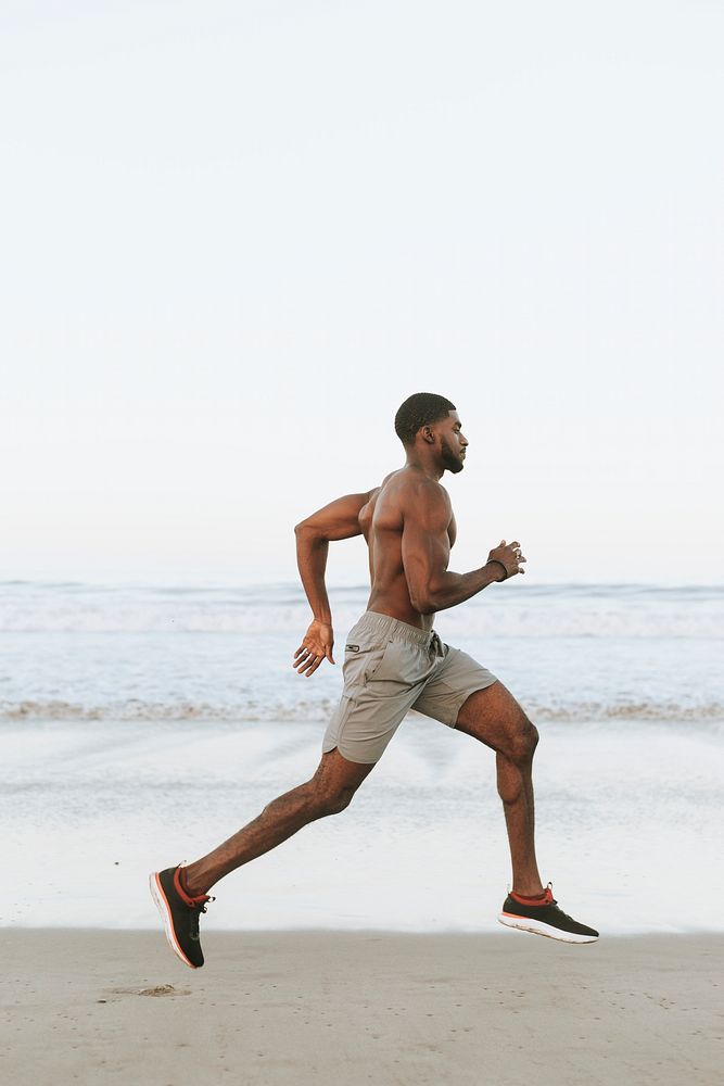 Fit man running at the beach in the early morning