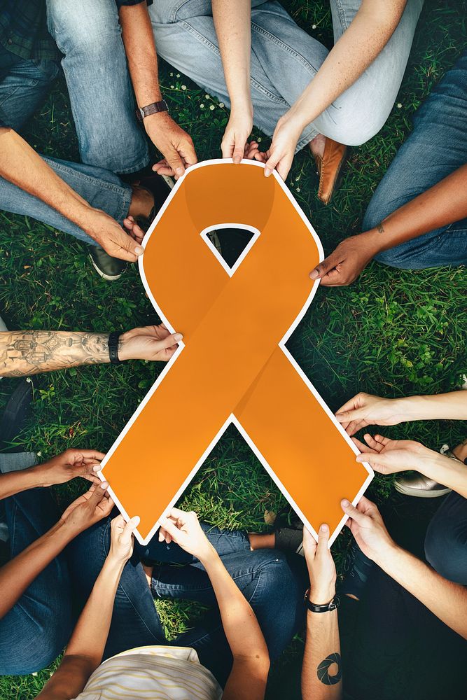 Group of people holding an orange colored ribbon