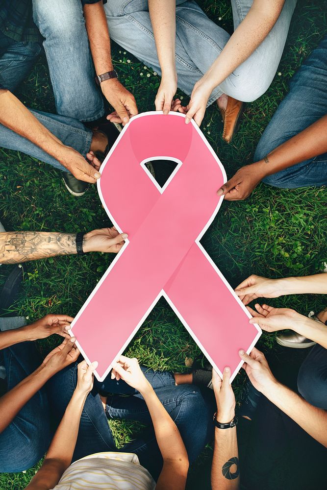 Group of people holding a pink colored ribbon