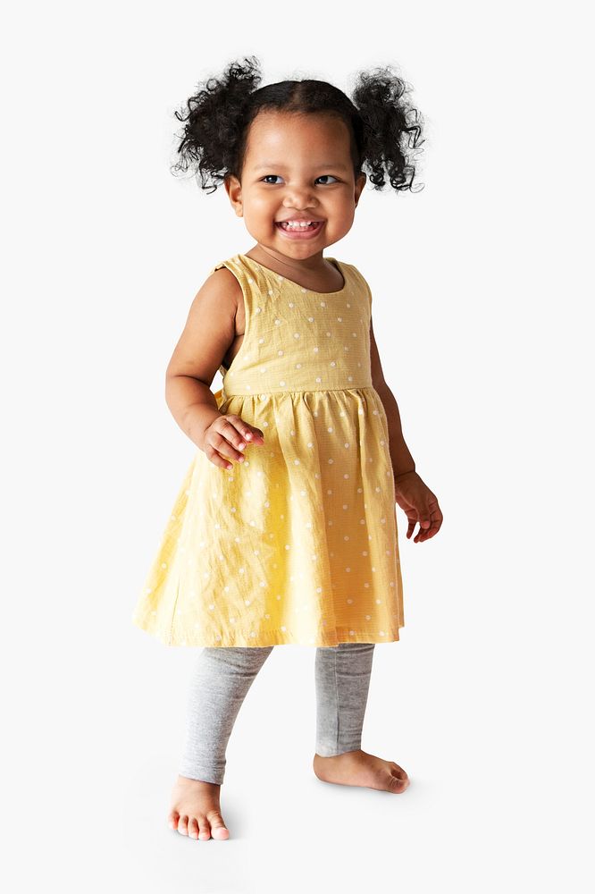 Happy little girl in a yellow dress standing