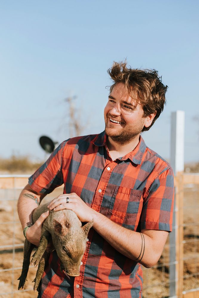 Happy young man with a piglet