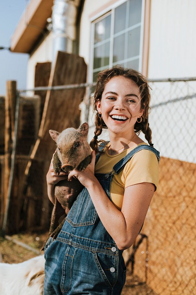Young volunteer with a piglet, The Sanctuary at Soledad, Mojave