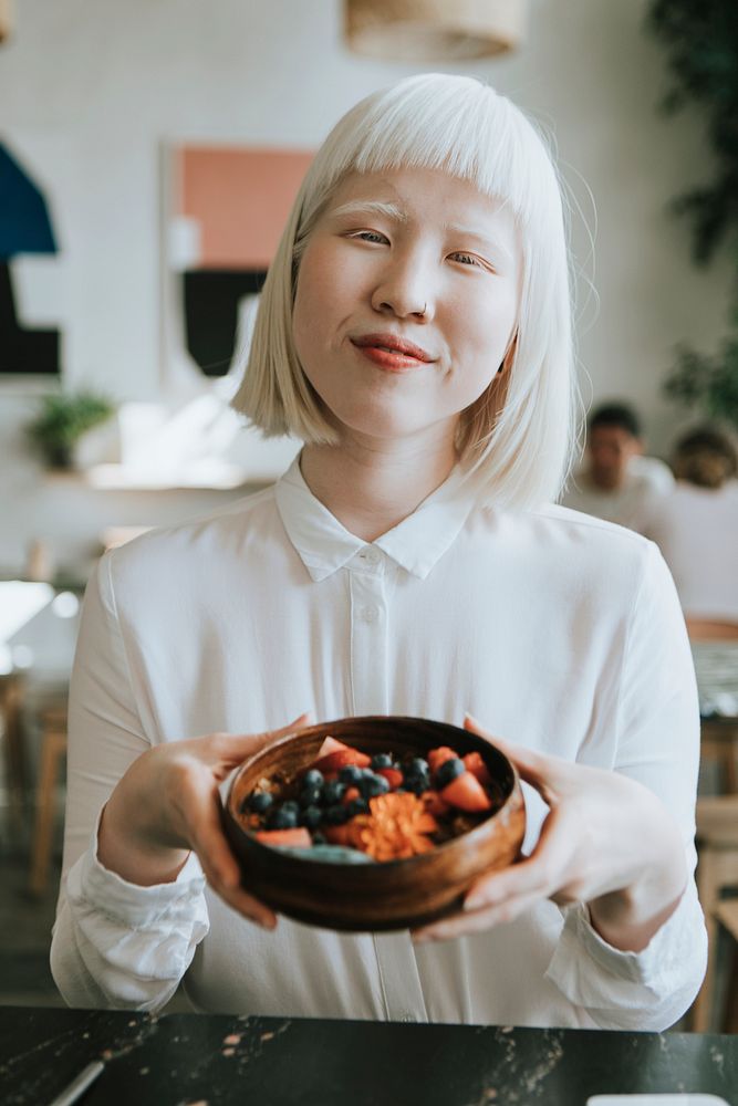 Albino girl having a healthy breakfast at a cafe