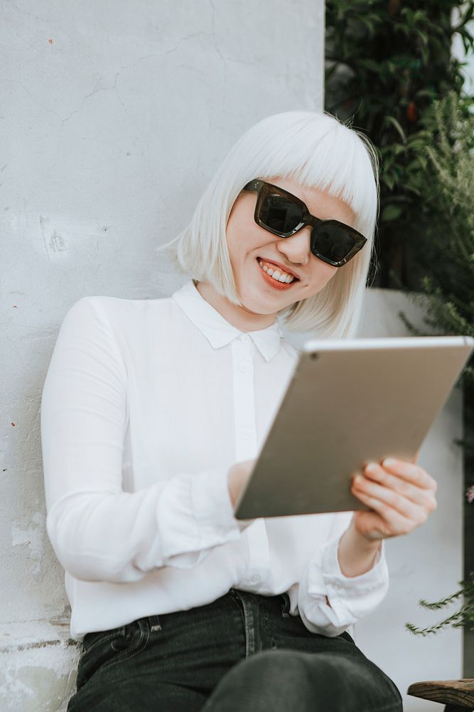 Cool albino woman working on a digital tablet