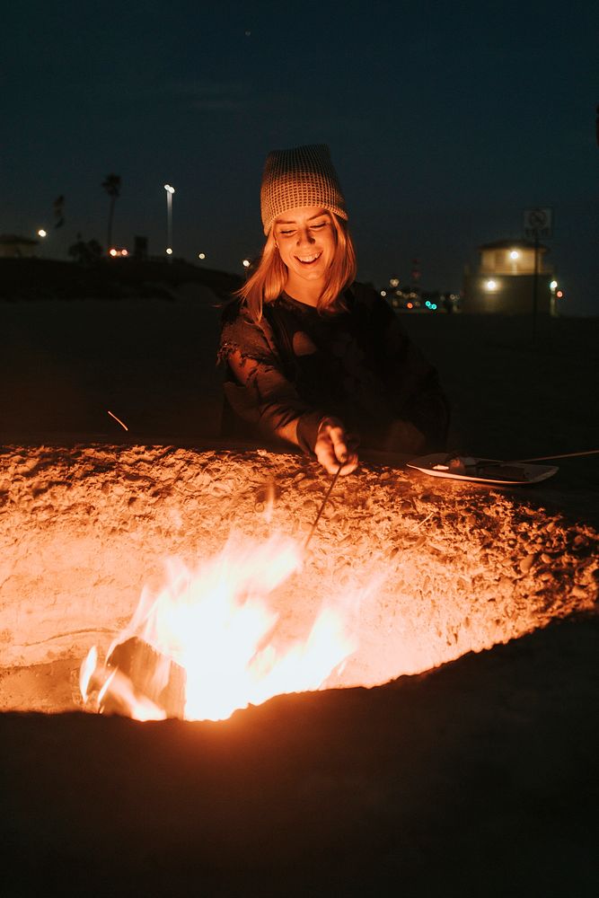 Woman roasting a marshmallow over a bonfire