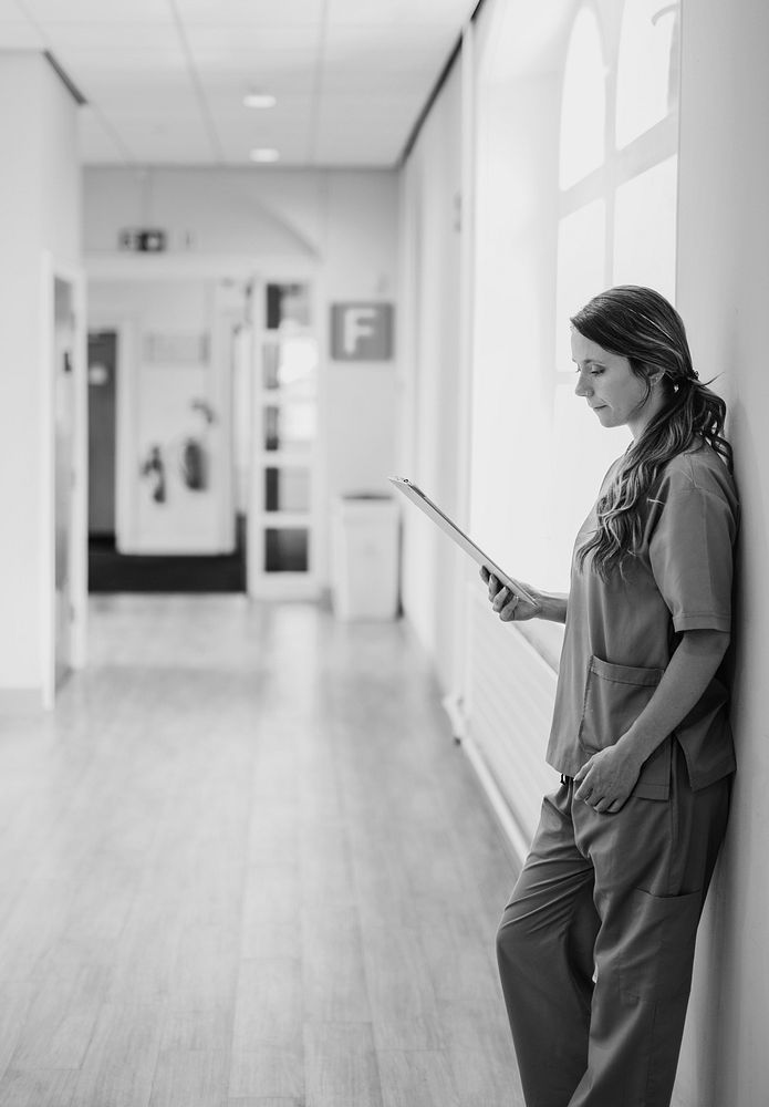 Nurse reading through medical records in the hallway