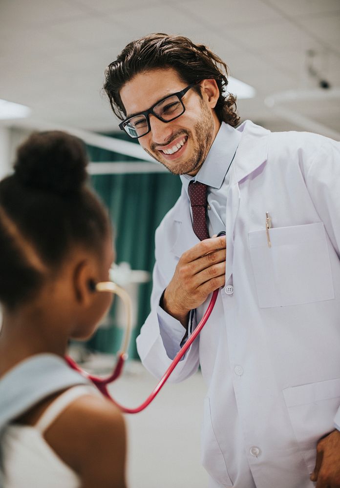 Friendly pediatrician entertaining his patient