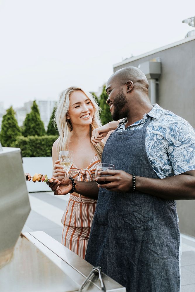 Couple enjoying barbeque skewers and a glass of wine