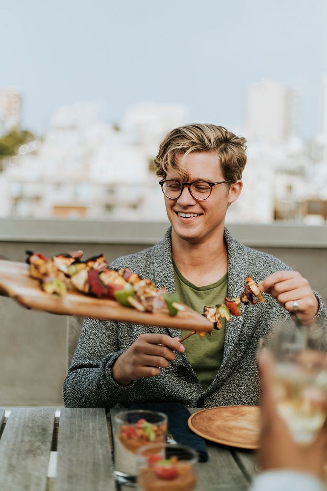 Happy man being served with vegan barbeque skewers