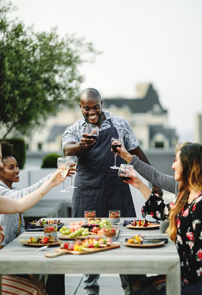 Friends toasting with the chef at a summer party