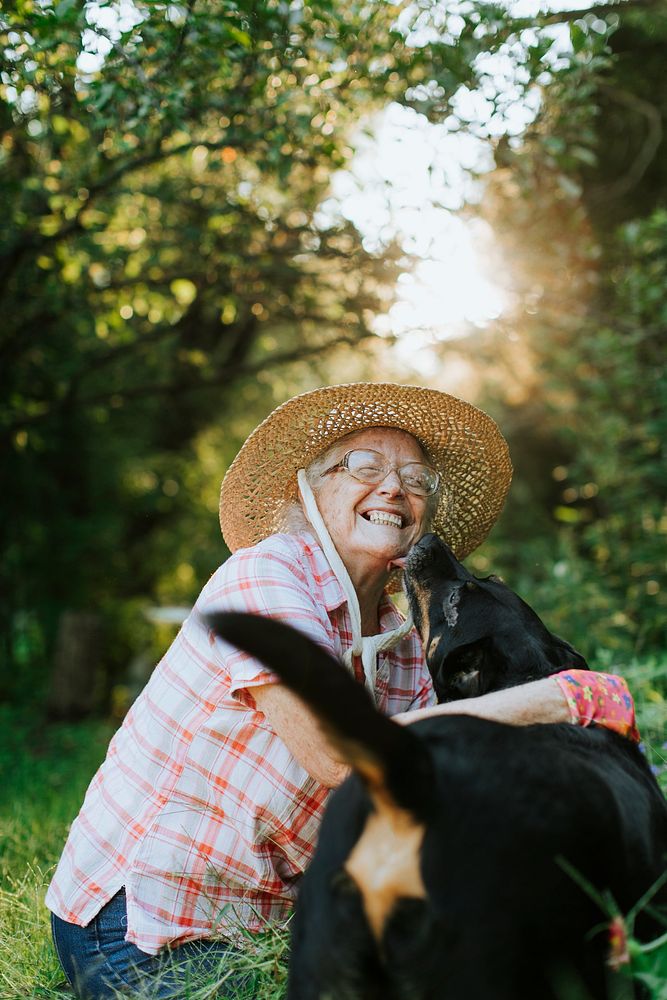 Happy senior woman getting kisses from her dog