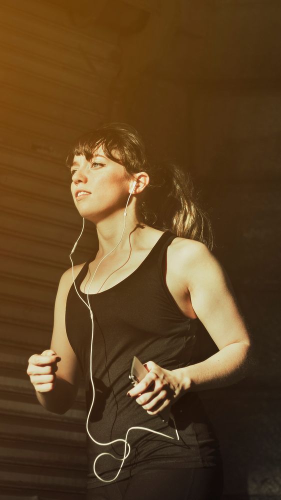 Woman listening to music while running mobile wallpaper