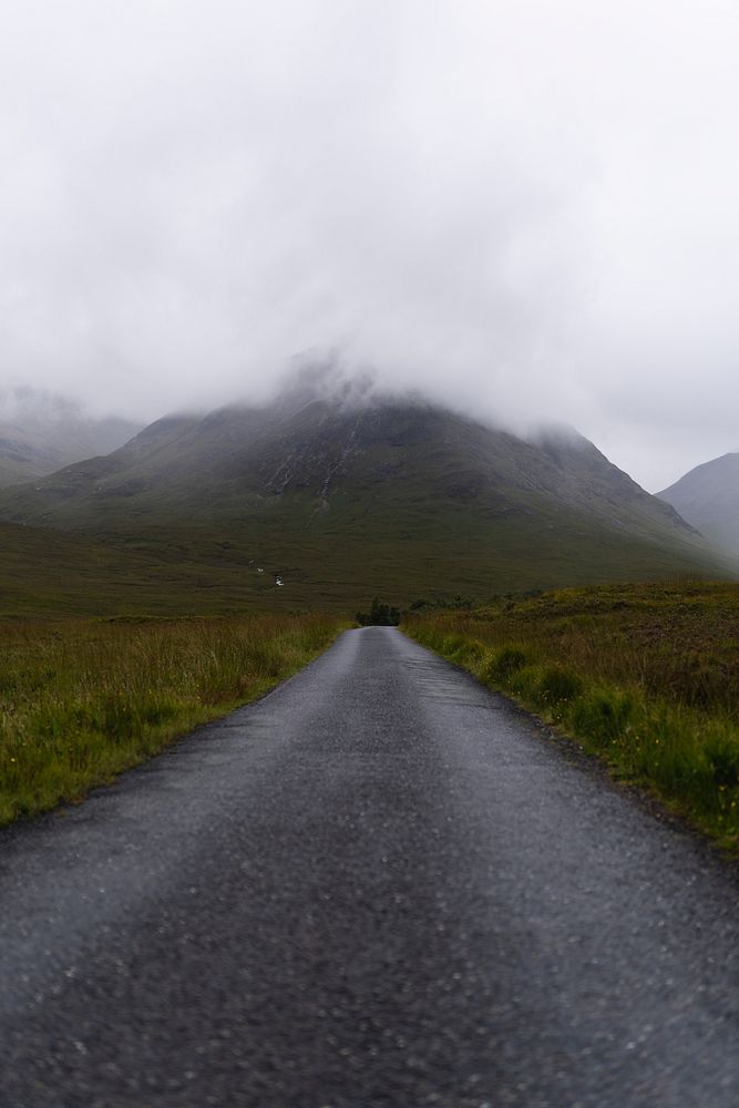 View of an empty road through the misty mountains in Glen Etive, Scotland