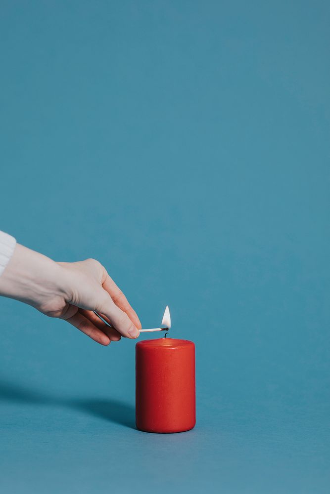 Woman lighting a red candle Premium Photo rawpixel