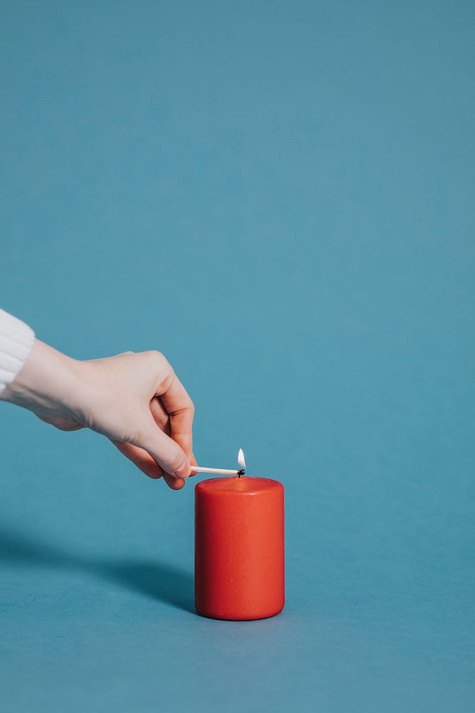 Woman lighting a red candle