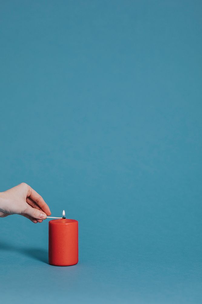 Woman lighting a red candle
