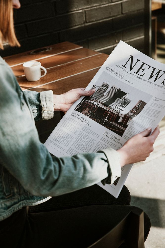 Woman reading a newspaper in a cafe