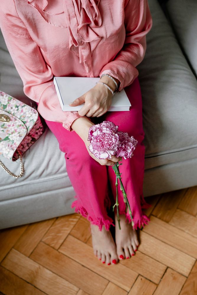 Woman holding white and pink carnations