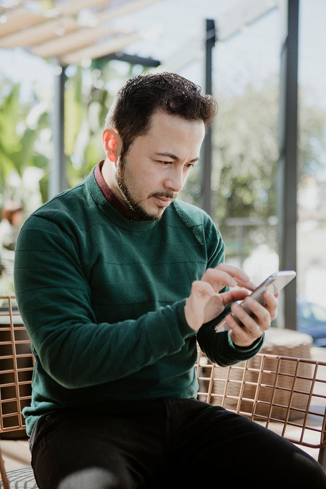 Man using a smartphone in a cafe