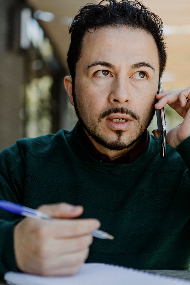 Man taking notes while talking on the phone