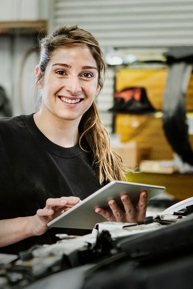 Female mechanic running a diagnostic on a car engine