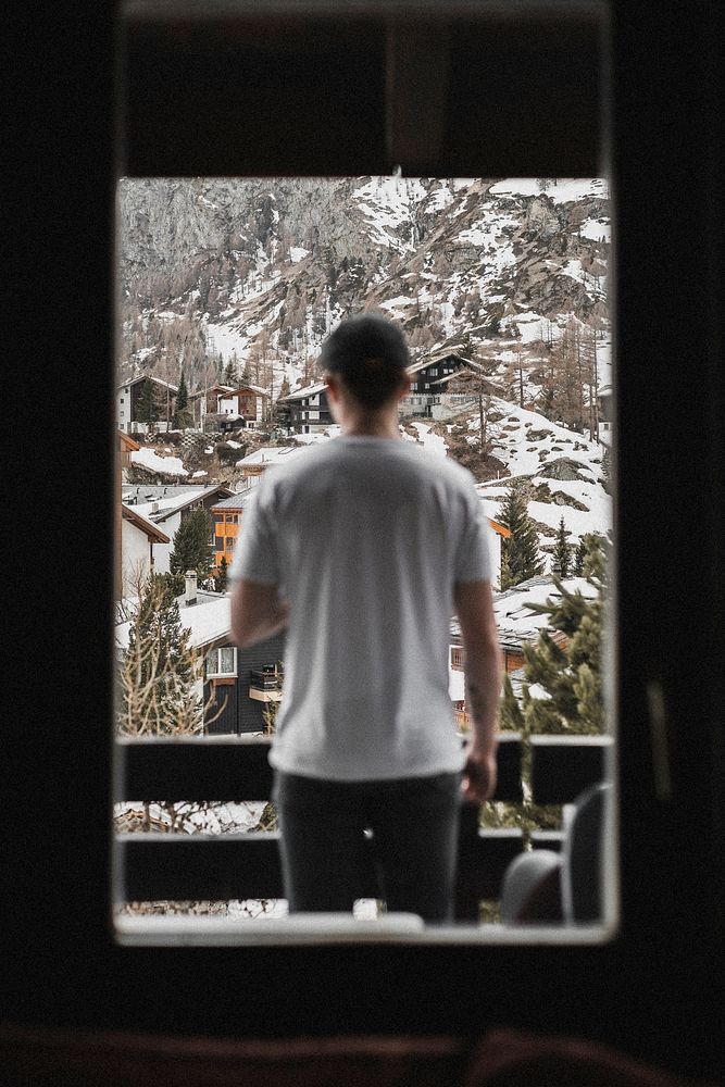 Man enjoying a view of the snowy village on the hills