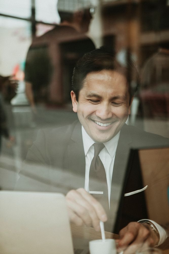 Happy businessman stirring his coffee shot