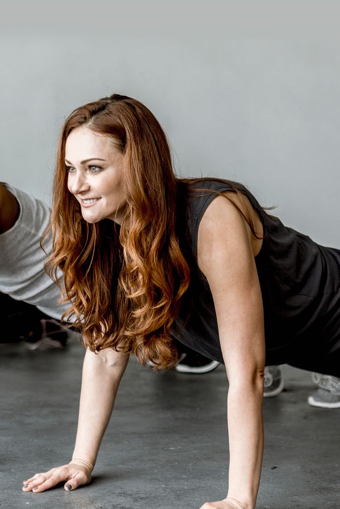 Cheerful woman praciticing a Phalakasana pose