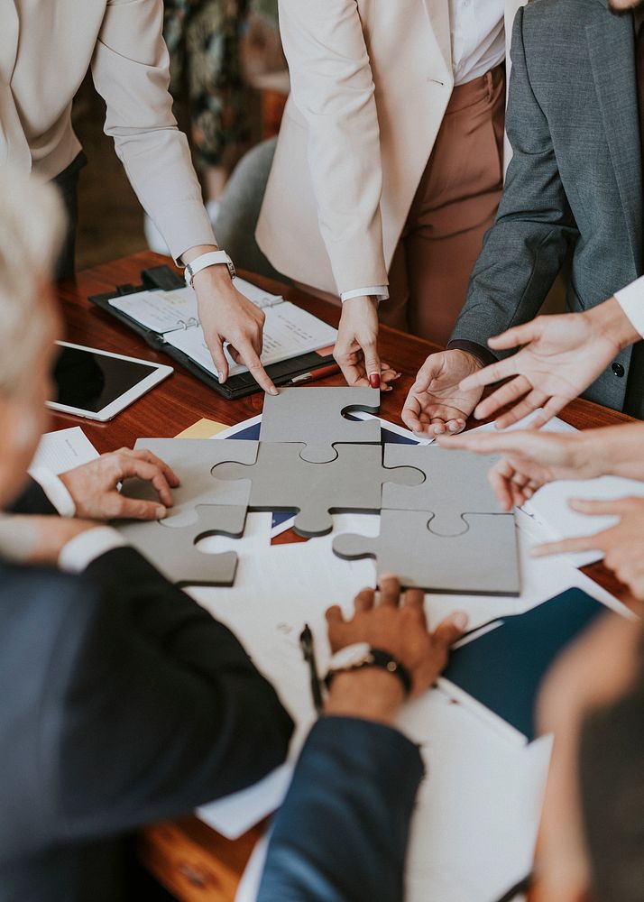 Business people connecting puzzle pieces together