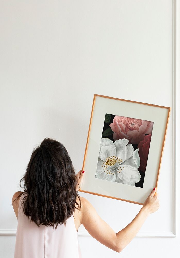 Curator hanging floral art frame mockup on the wall