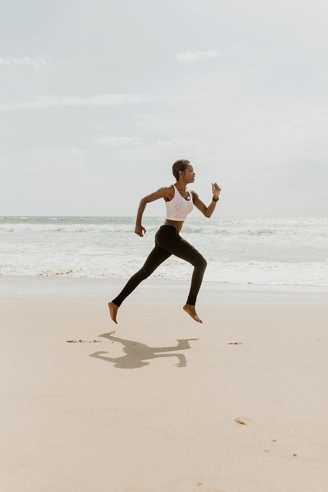 Black woman running at the beach