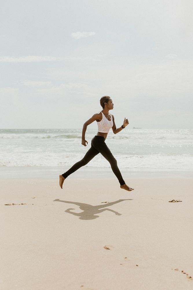 Black woman running at the beach