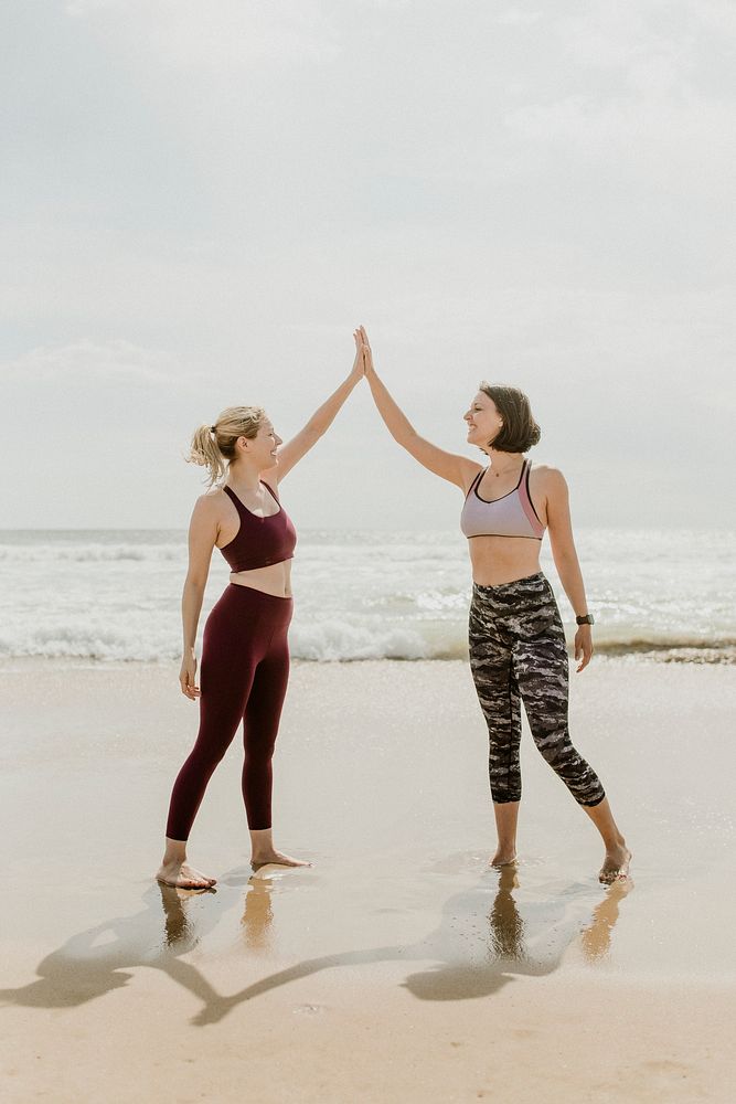 Cheerful sporty women bonding at the beach