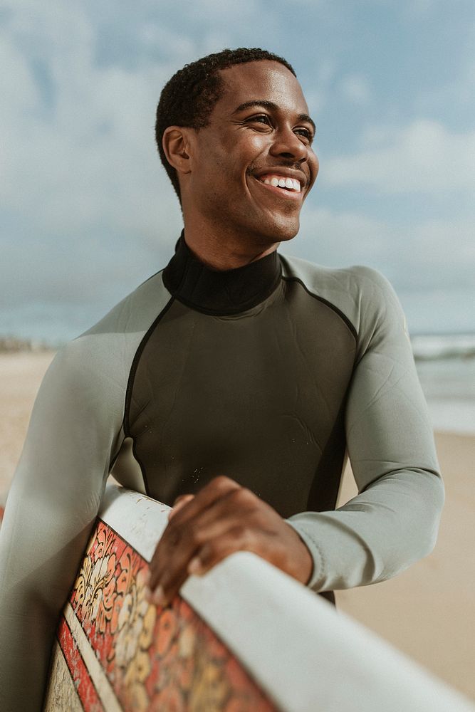 Cheerful man with a surfboard at the beach