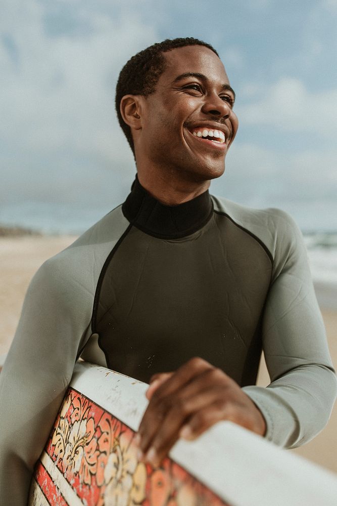 Cheerful man with a surfboard at the beach