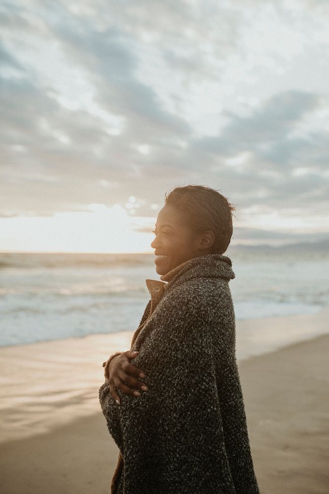 Cheerful woman on the beach on a cold summer night