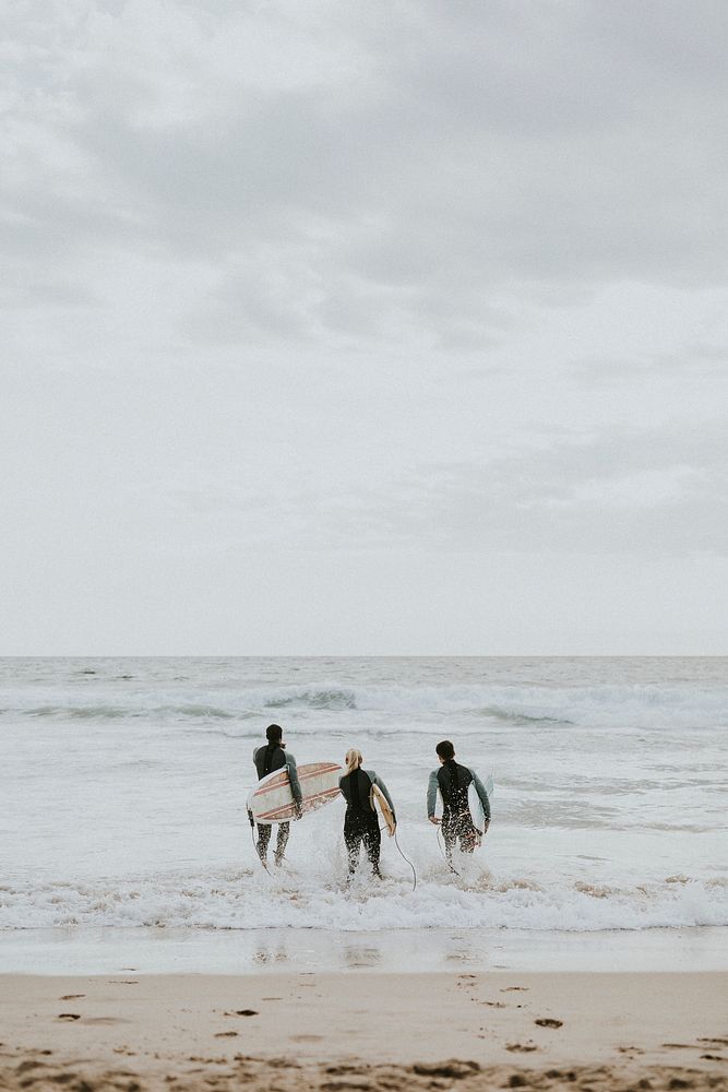 Happy friends surfing at the beach