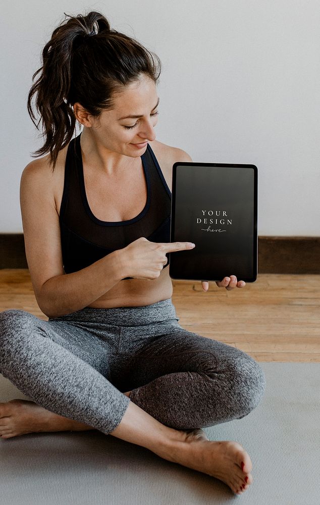 Yoga instructor showing a digital tablet mockup