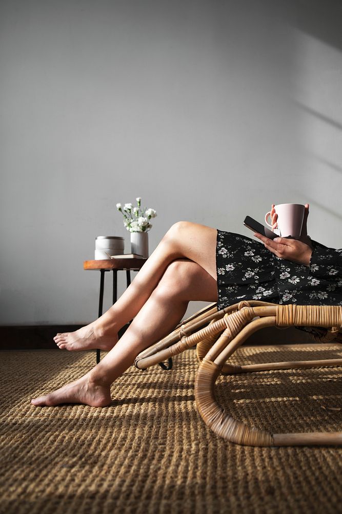 Woman sitting on a wicker seat with a cup of tea
