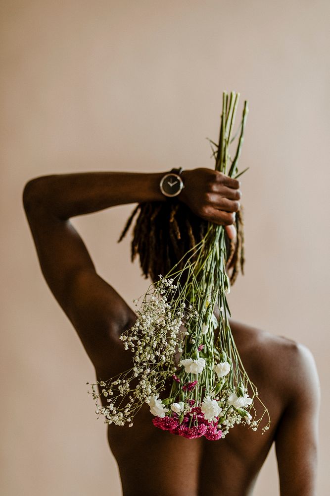 Black man carrying a bouquet of flowers on his back