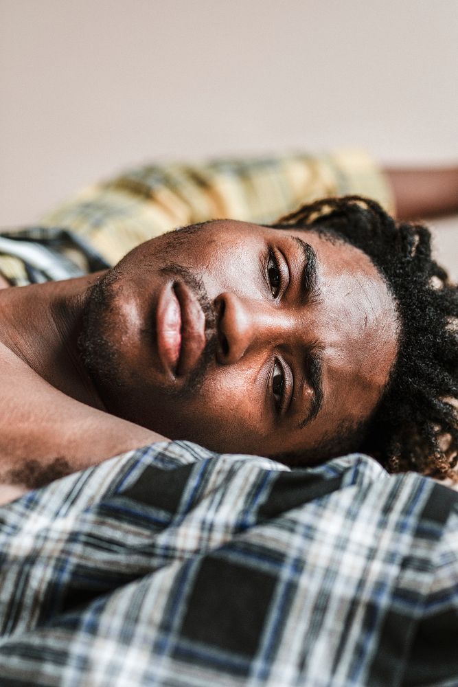 Black man lying on a plaid t-shirt