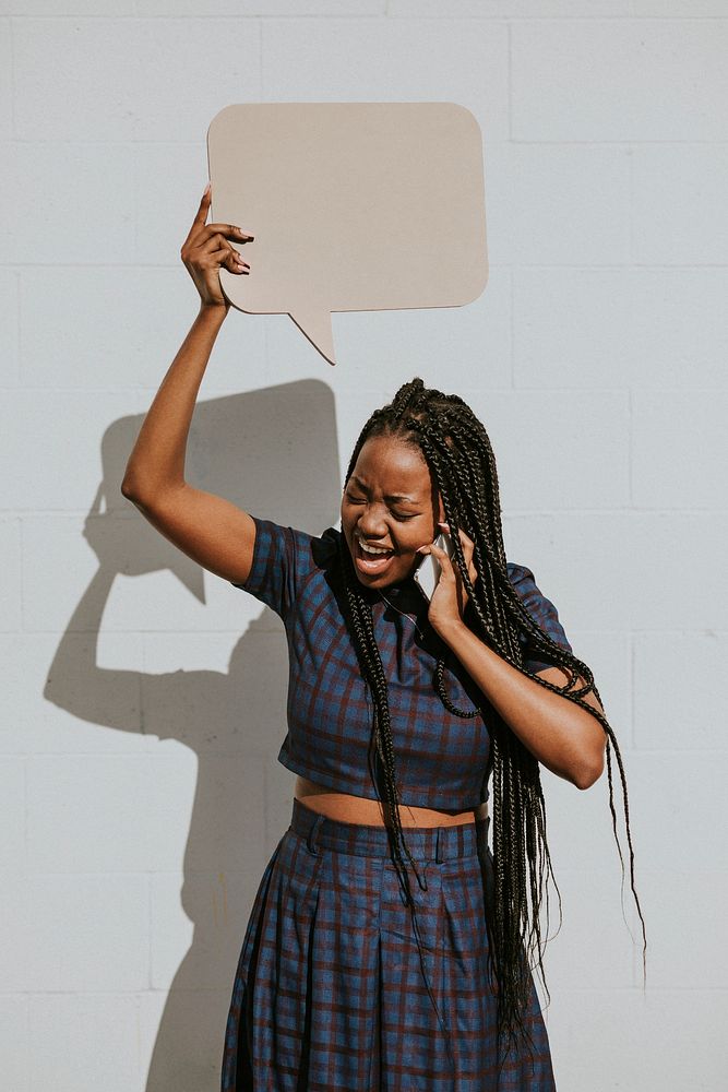 Black woman showing a blank speech bubble while talking on a phone