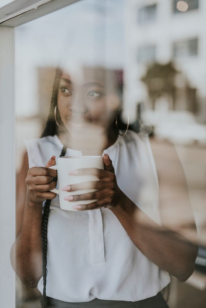 Woman enjoying a cup of coffee while looking out the window