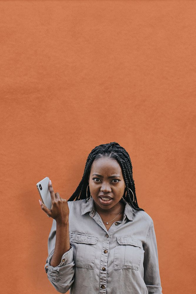 Serious black woman with her phone in a hand