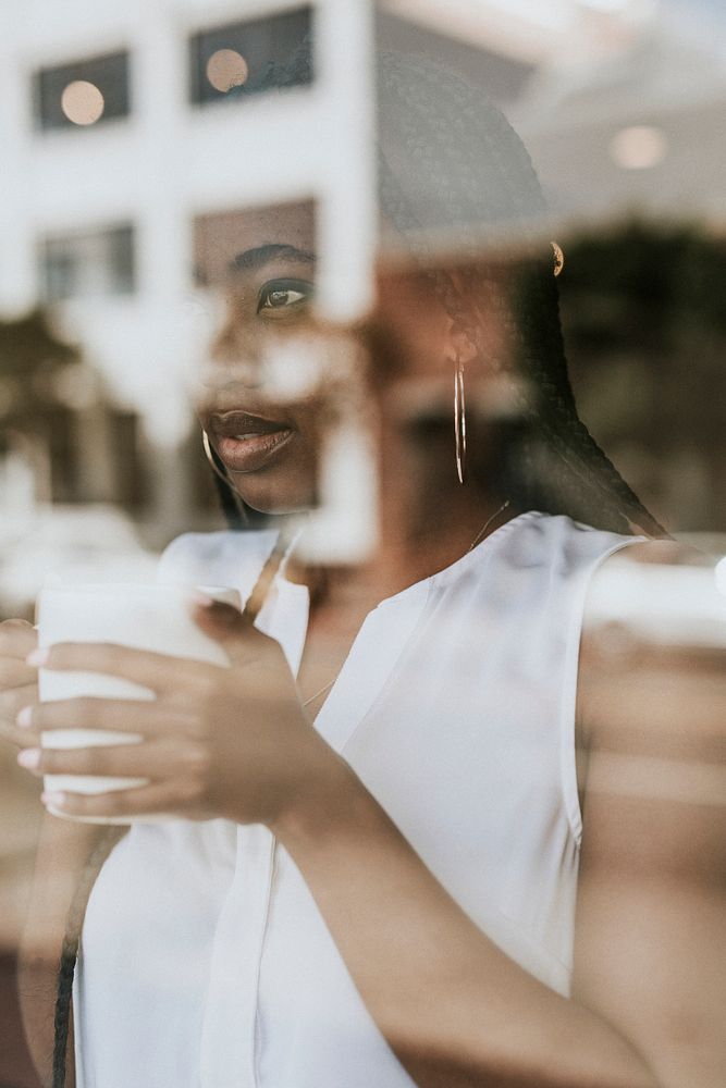 Woman enjoying a cup of coffee while looking out the window