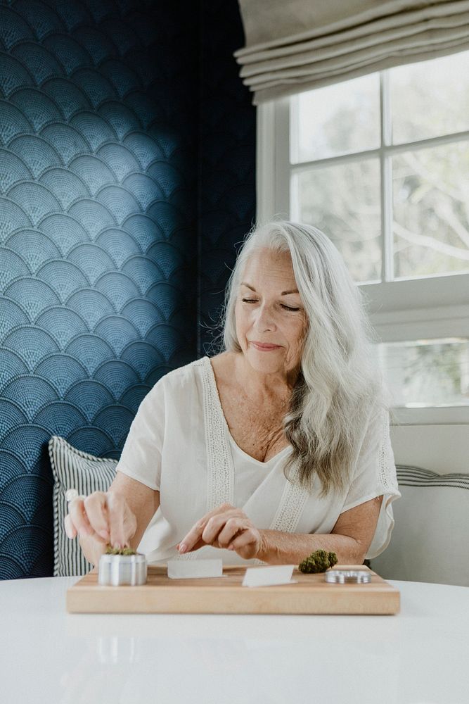 Senior woman rolling a joint